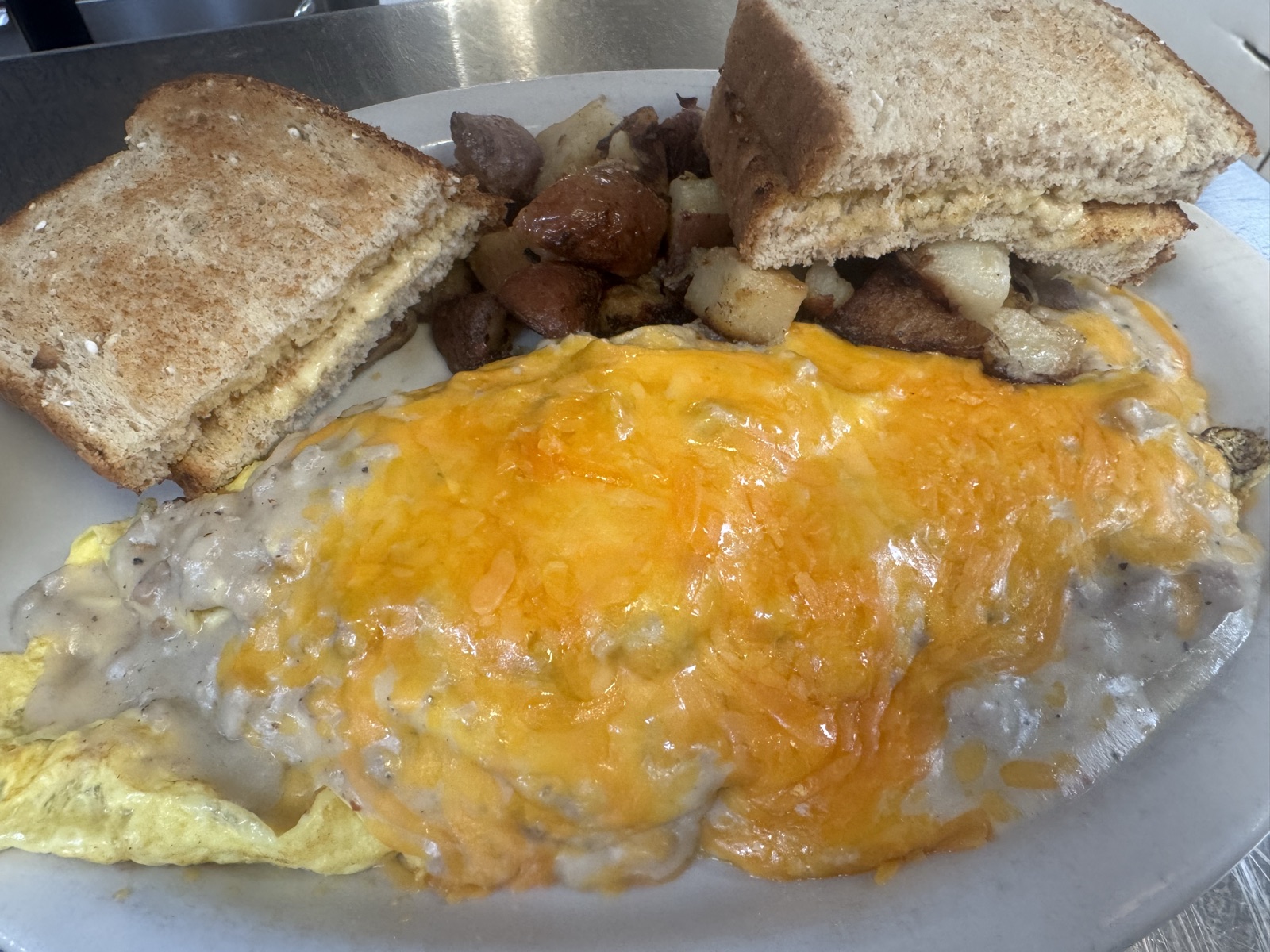 A cheese omelet served with potatoes and toast